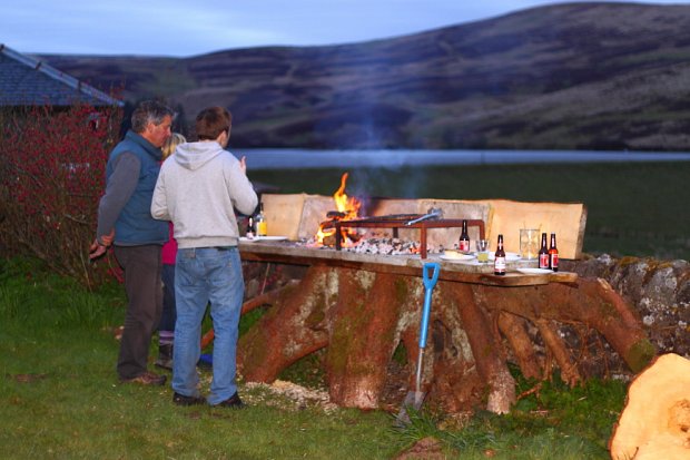 Standing round the fire enjoying the view and a burger